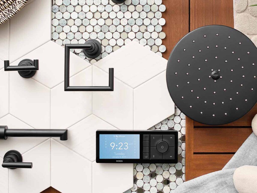 A designer's flatlay of various shower parts and tile, including the Moen digital thermostatic shower control.