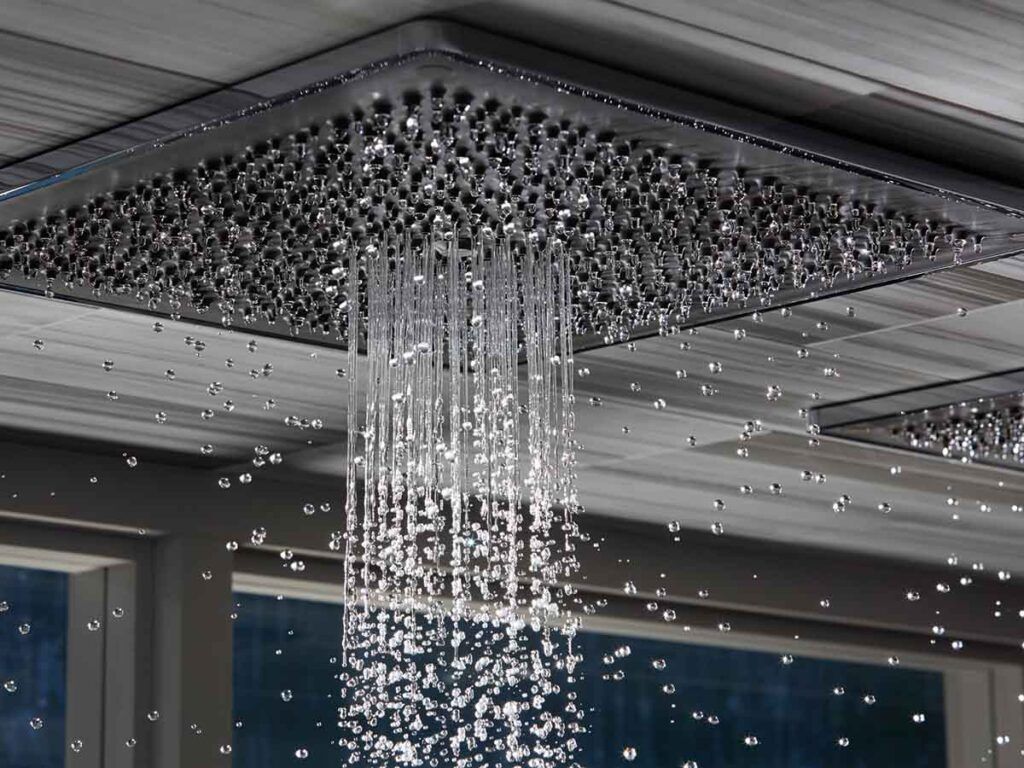 A ceiling mounted rainshower spraying water.