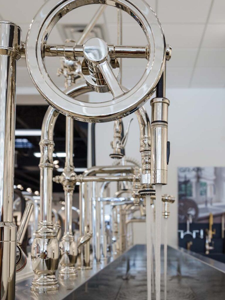 A detail shot of a working faucet display in a studio41 showroom, featuring Water Street Brass semi-professional faucets