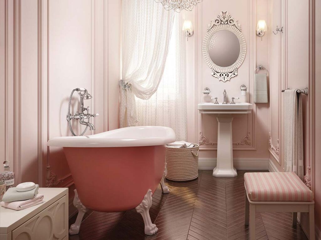 Coquette pink bathroom with  clawfoot pink tub, soft pink walls, and a stately pedestal sink.