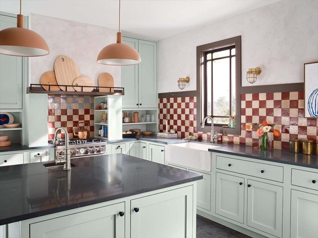 A green and red transitional kitchen with a white apron front farmhouse sink.
