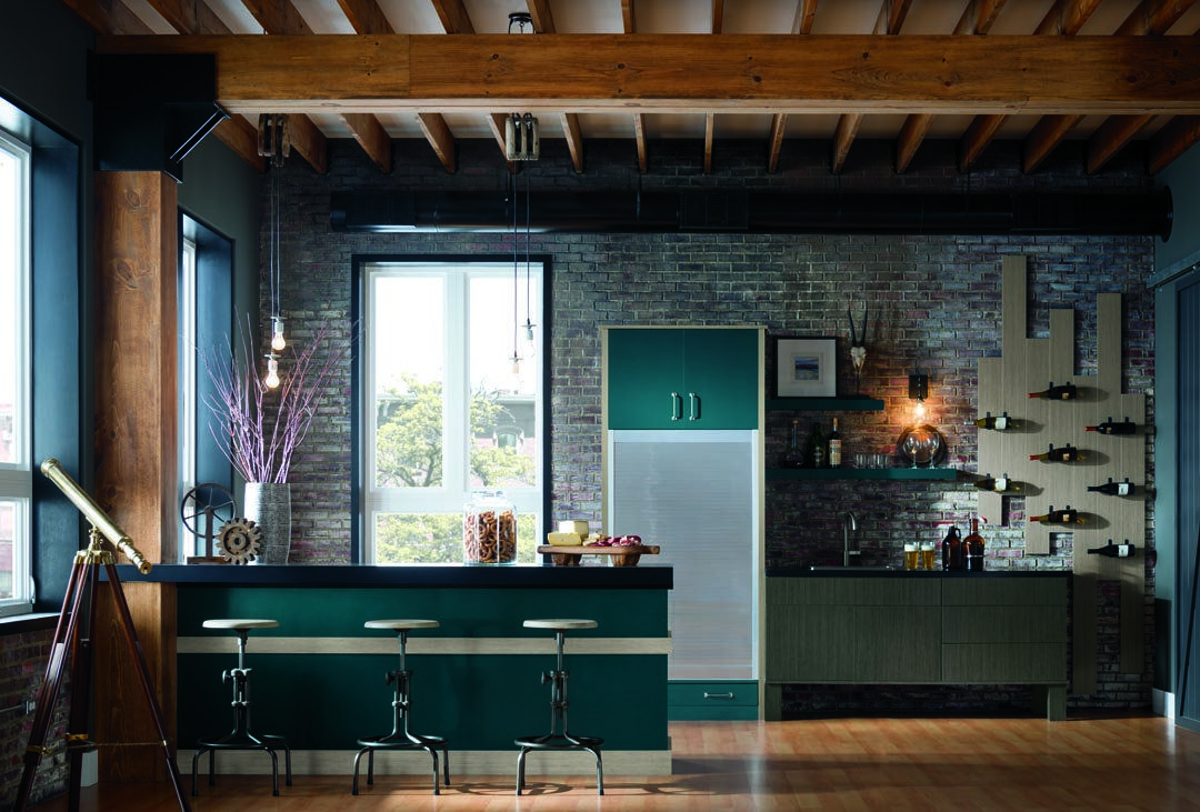 Quirky and metropolitan kitchen with brick walls and dark teal cabinets. Featured cabinets are custom Omega Nella doors.