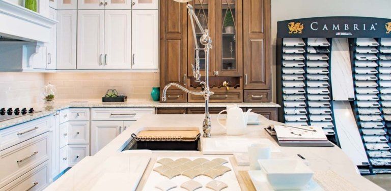 A Studio41 kitchen showroom vignette with an ornate faucet, a countertop display, and tile options