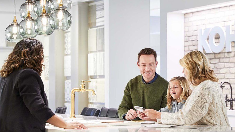 A studio41 product expert helping a young couple plan their renovation in a showroom