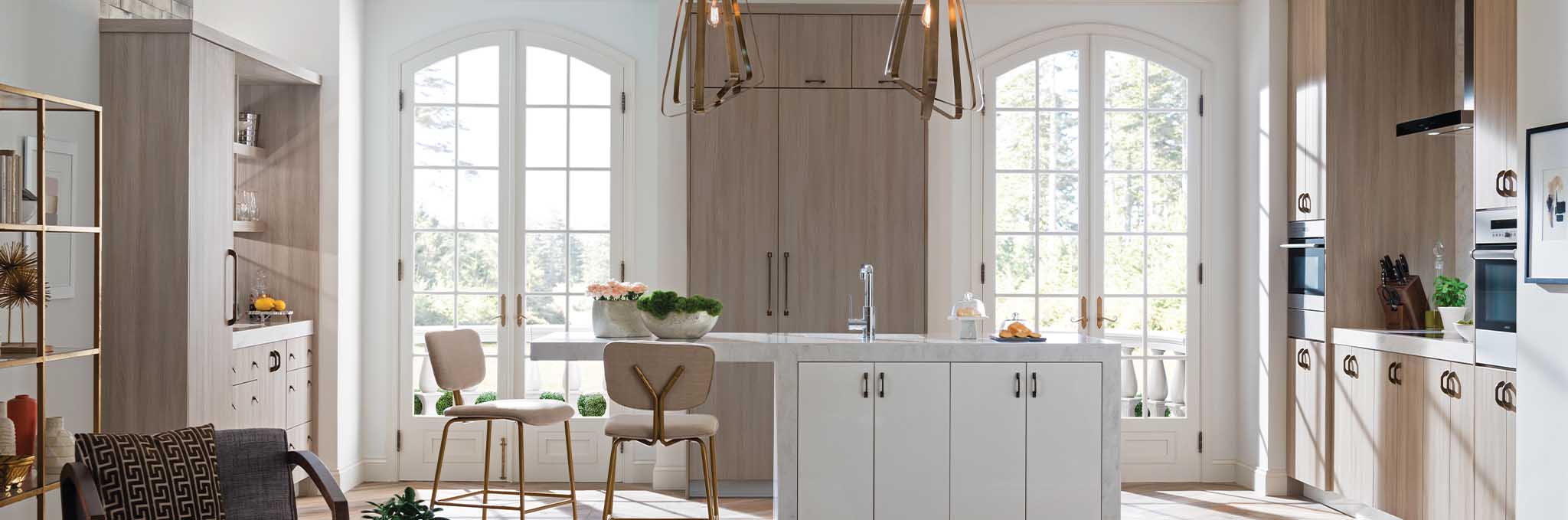 A open, modern kitchen in soft beige and gray colors. Featuring Ultracraft cabinetry.